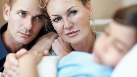 Besorgte Eltern am Krankenhausbett