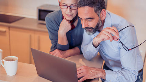 Zwei Menschen sitzen vor dem Computer