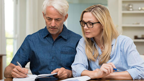 Ehepaar schreibt notitzen ins Herztagebuch