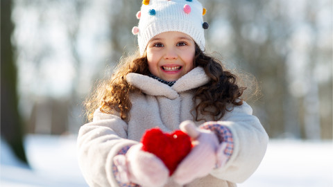 Kind hält ein Herz hoch