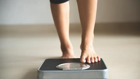 Frau steht auf einer Waage